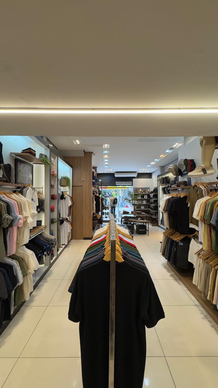 Corredor central da loja com camisetas coloridas